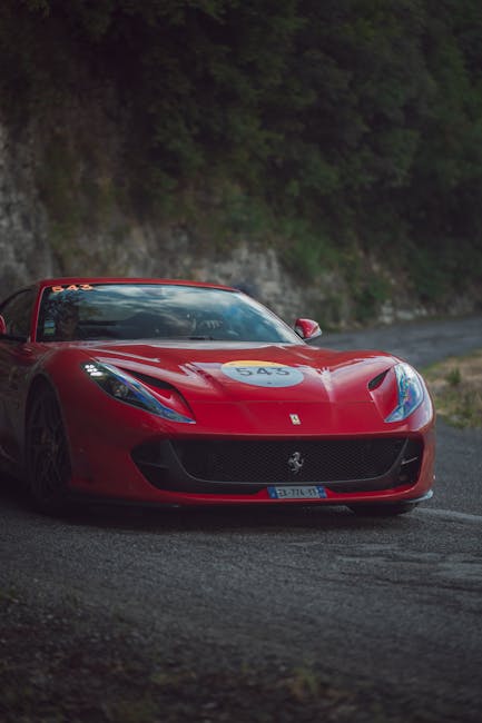 Luxury Cars - A striking red Ferrari sports car navigating a s #13971807
